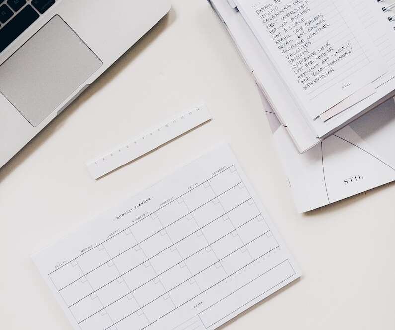 silver laptop computer near notebook