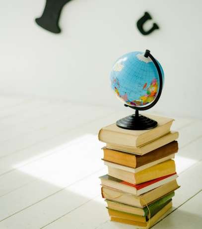 blue and yellow desk globe on yellow and white books